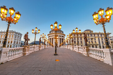 Art bridge in Skopje with lights and sculptures at sunset.