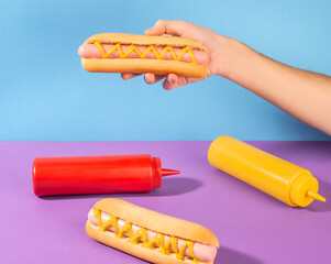 Hand giving a fresh hotdog with mustard