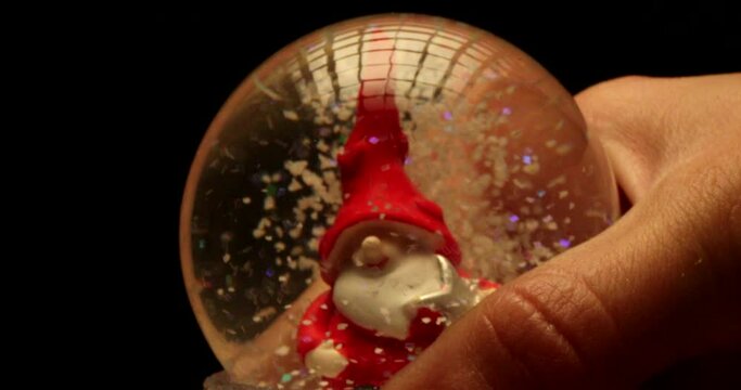 Slow motion footage of snow falling on Santa Claus in magical glass ball. Christmas concept