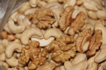 A scattering of different cashew nuts and walnuts. Crop of nuts. Background