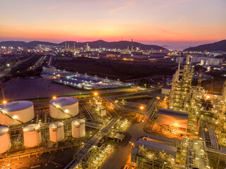 Aerial view of pipe and chemical oil refinery plant, power plant and metal pipe on sunset sky background.