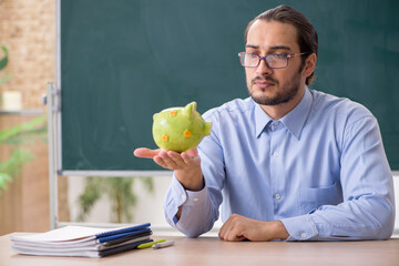 Young underpaid male teacher in the classroom