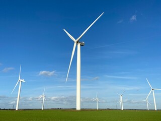 Fototapeta premium Wind farm turbines that produce electricity energy. Windmill Wind power technology productions Wind turbines standing in green field - stock footage