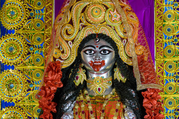 Idol of Goddess Maa Kali at a decorated puja pandal in Kolkata, West Bengal, India. Kali puja also known as Shyama Puja is a famous religious festival of Hinduism. - obrazy, fototapety, plakaty