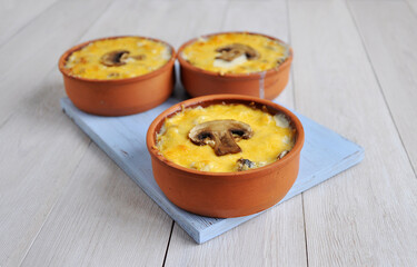 Homemade mushroom julienne in ceramic cocotte. Sliced champignons.