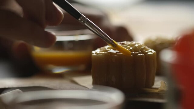 Chef hand making Mooncake a Chinese traditional pastry for Mid-Autumn festival. set on rustic wooden table.