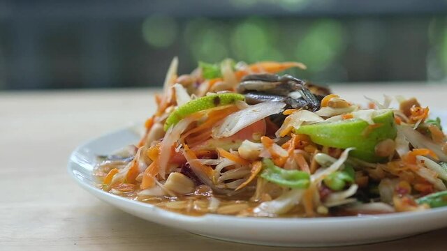 Thai papaya spicy salad or known as Somtum into a plate. Thai traditional street food style