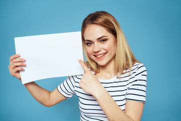 Woman holding sheet of paper striped T-shirt Copy Space cropped view blue background