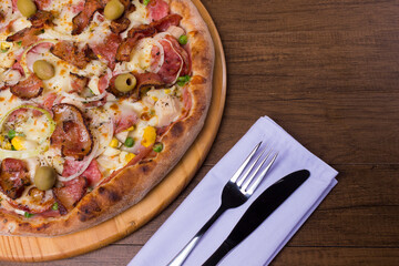 Complete Portuguese Pizza, made with ham, pea egg, heart of palm, pepperoni, onion and mozzarella and bacon. Top photograph with upper right space for texts.