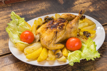 Chicken plate with potatoes with rustic wooden background.