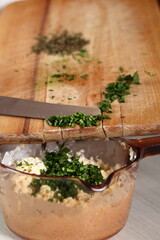 Add minced parsley into bowl with filling. Making Salmon in Puff Pastry Series.