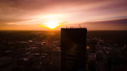 Looking into rising sun from Lexington, Kentucky downtown district with silhouette projections of tall office buildings