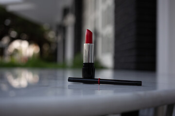 Red lipstick and lip pencil on the table outside. decorative cosmetics. High quality photo