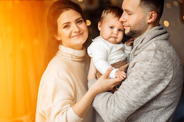 Fototapeta premium Lovely parents with little daughter spend winter holidays at home, loving father hold cute toddler in arms, enjoy tender moments, Christmas and new year celebration concept