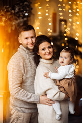 Caring parents with little baby girl spend winter holidays at home, loving mother hold cute toddler in arms, enjoy family moments, Christmas and new year celebration concept