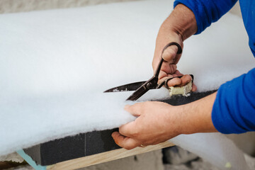 Furniture maker cutting a sofa padding - obrazy, fototapety, plakaty