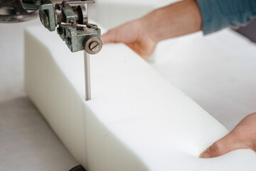 Closeup of a foam cutter machine, cutting through an upholstery foam