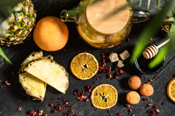 Fruit hot tea with the addition of oranges, lemons, mandarins and raspberries in a glass cups on a table. Healthy hot drink. tea with fruit and berries in a glass teapot. tea for colds.