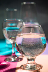 glasses of water stand on multi-colored paper
