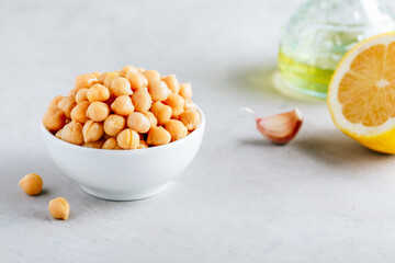 Cooked Chickpeas in white bowl on gray stone background