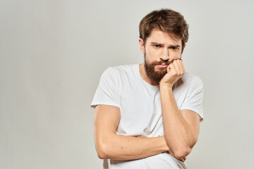 man in white t-shirt gesturing with his hands studio dissatisfaction lifestyle light background