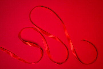 Red ribbon on a red background. Holiday decorations. Christmas concept. 