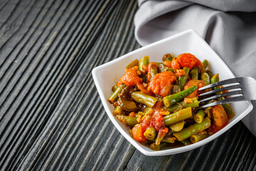 stewed green beans on a dark wooden rustic background