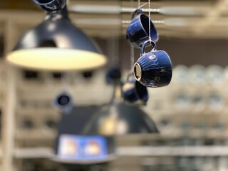 照明器具の横にぶらさがった青いコーヒーカップ