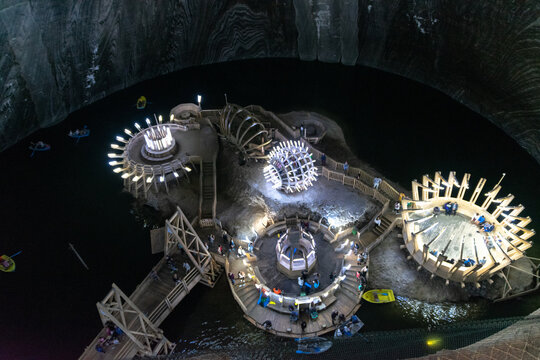 SALINA TURDA, ROMANIA - AUGUST 4, 2018: The underground lake and UFO-shaped constructions at the Turda salt mine in Romania, ranked among the 25 hidden gems around the world that are worth the trek