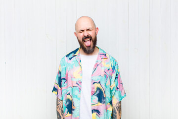 bald man with cheerful, carefree, rebellious attitude, joking and sticking tongue out, having fun