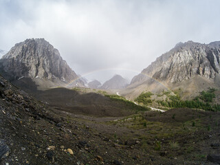 Photo of a Mountain Sunny Landscape with Rainbow after Rain