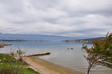 Stone breakwater on sand beach on autumn. Croatian beach.