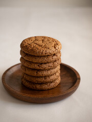Oatmeal cookies in a wooden plate on a white background in the morning light close up