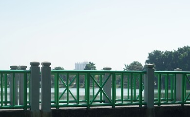 A Pune Bridge in Bueng have a green fence for walk way in the park.