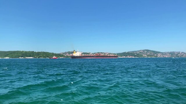 Footage of a dry cargo vessel passing on Bosphorus strait in Tarabya area of Istanbul. Asian side is in the view. It is a sunny summer day.