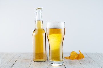 A bottle of beer and a glass of high foam. Beer lager in glass and bottle.