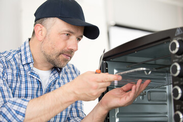 handyman assembling an oven