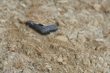 Schwarze Pistole an einem Tatort auf dem Boden liegend