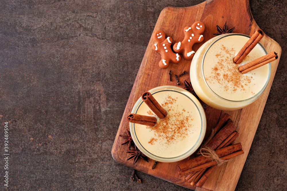 Poster spiced christmas eggnog. overhead view on a serving board with copy space on a dark stone background