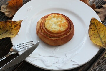 Delicious bun with cottage cheese on a wooden table 