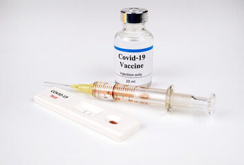 Test kit for viral disease COVID-19  Lab card kit test for viral novel,rapid test kit for corona virus covid-19,vaccine bottle and syringe blur in background.Selective focus on Test kit.
