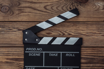 Film clapper board on wooden background. Cinema industry, entertainment. Top view