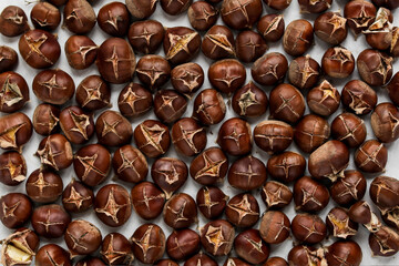 Lots of baked chestnuts on a baking sheet. View from above. Background.