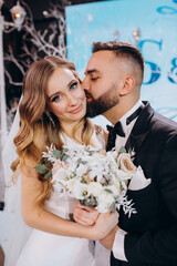 Beautiful photo session of the bride and groom on stage. Wedding ceremony. Beautiful decorations. Blue background.
