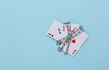 Four aces wrapped in a steel chain on a blue background. Prohibition of gambling business, casinos