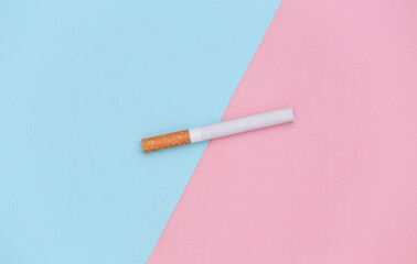 Cigarette on a blue-pink pastel background. Minimalism. Top view