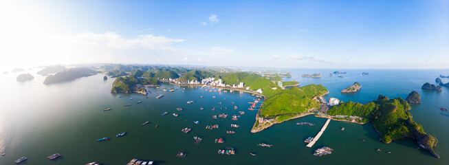 Aerial unique view Vietnam Cat Ba bay with floating fishing boats on sea, cloudscape tropical weather inspirational sunset, epic city skyline and skyscraper, scenic green mountain. © fabio lamanna