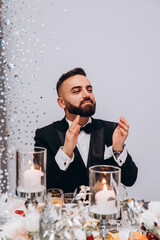 Portrait of the groom. The groom on stage is waiting for the bride. Blue background.
