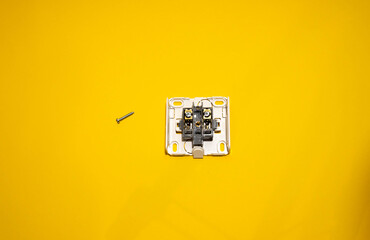 Disassembled socket on a yellow background. Space for text. Electrical works concept.