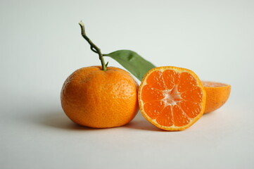 ripe and juicy tangerine (mandarin). fresh tangerine with leaf on white, closeup